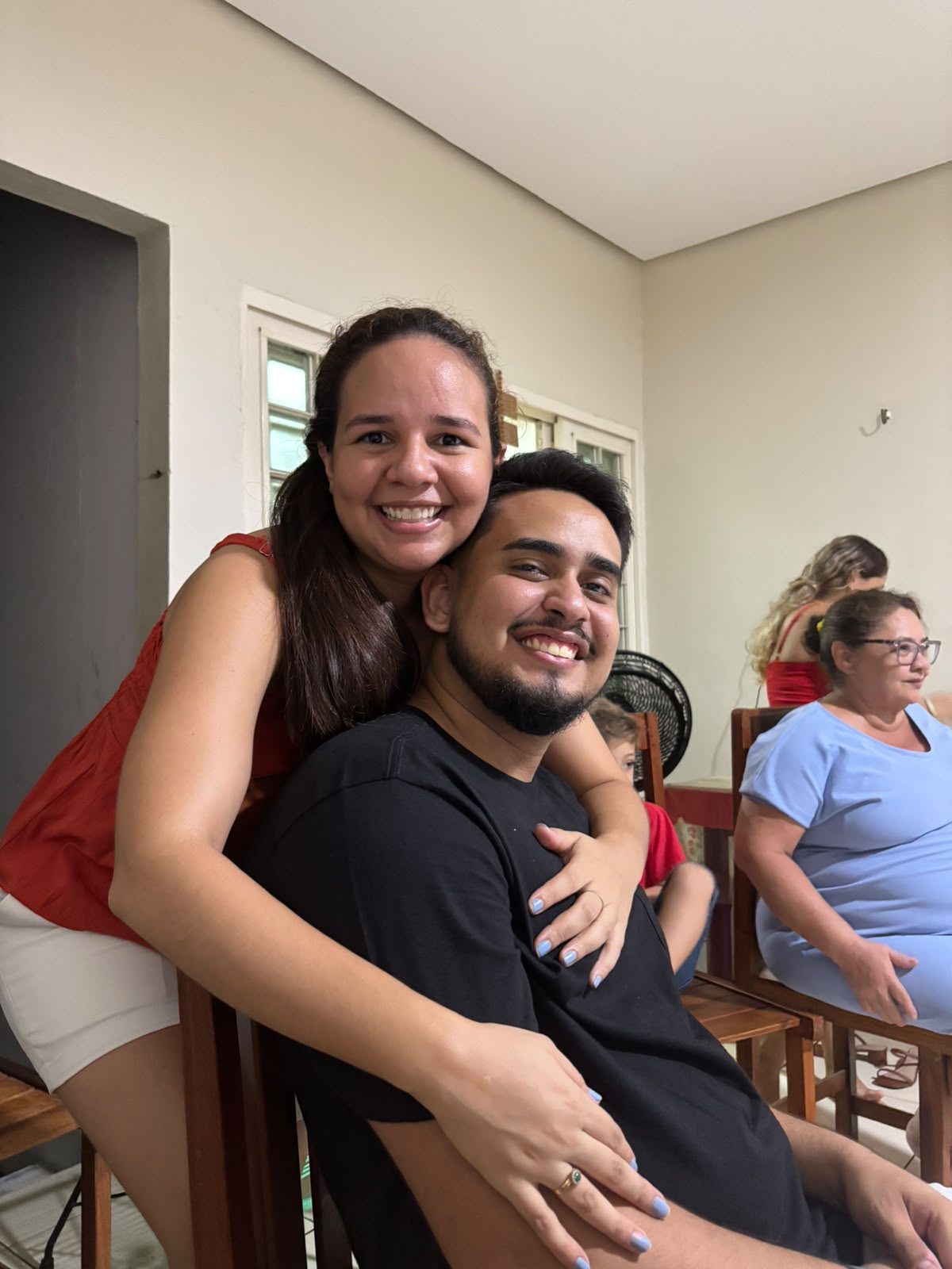 Ana abraça João por trás, os dois sorrindo