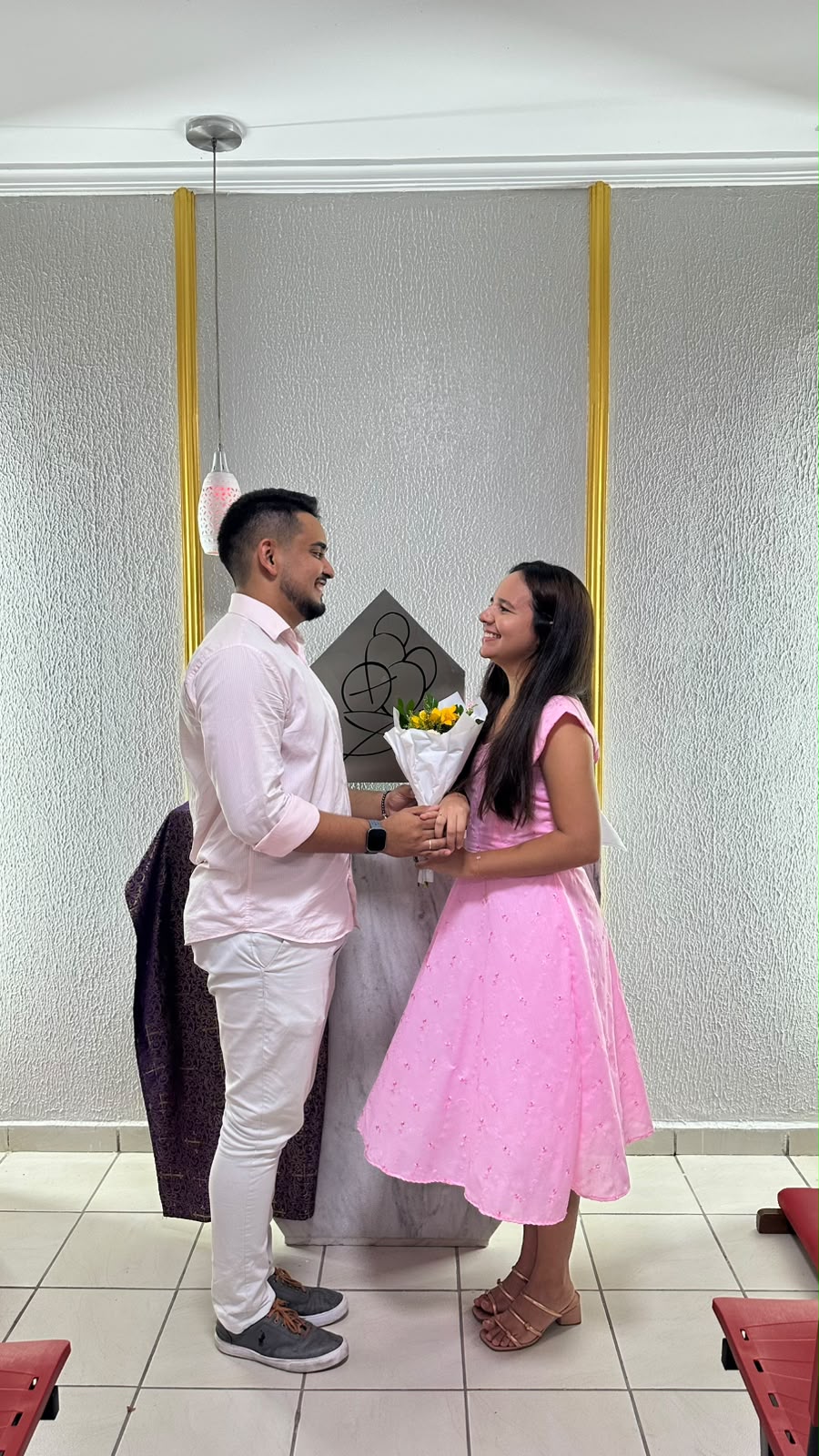 João e Ana em um instante de fé, com buquê amarelo